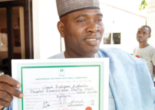 Jimoh-Agboola-Raheem-displaying-the-Certificate-of-Return-presented-to-him-by-INEC-516x367